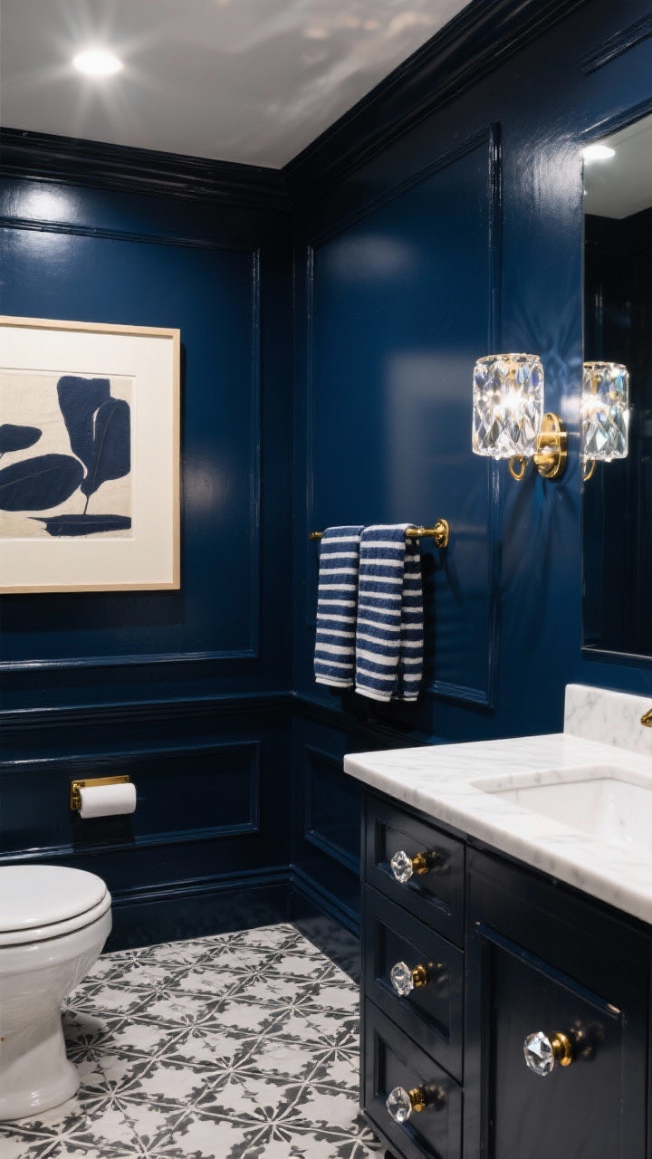 Photorealistic wide shot of an inky navy jewel box bathroom: walls and trim painted deep satin navy, white vanity with bright countertop for dramatic contrast; black-and-white encaustic-look patterned floor tile; polished lacquered brass hardware with faceted knobs; prismatic glass sconce adding sparkle; an oversized art print with a broad cream mat; navy-striped towels; controlled moody lighting with gentle reflections, corner angle, no people.